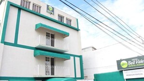 A hotel named Bell Vale with a green and white facade, balconies, and a sign indicating special promotion. - Hotel Bell Vale (São José dos Campos)