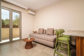 Junior Suite Apartment | Área de sala de estar | Televisión de pantalla plana