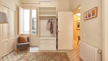 A bedroom with a bed, a chair, a wardrobe, and a radiator.