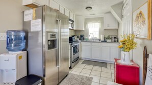 A modern kitchen with a stainless steel refrigerator, a water dispenser, a microwave, and a stove. - Country cottage beside stocked pond on 40 acres and Blue ridge Mountain View (Front Royal)