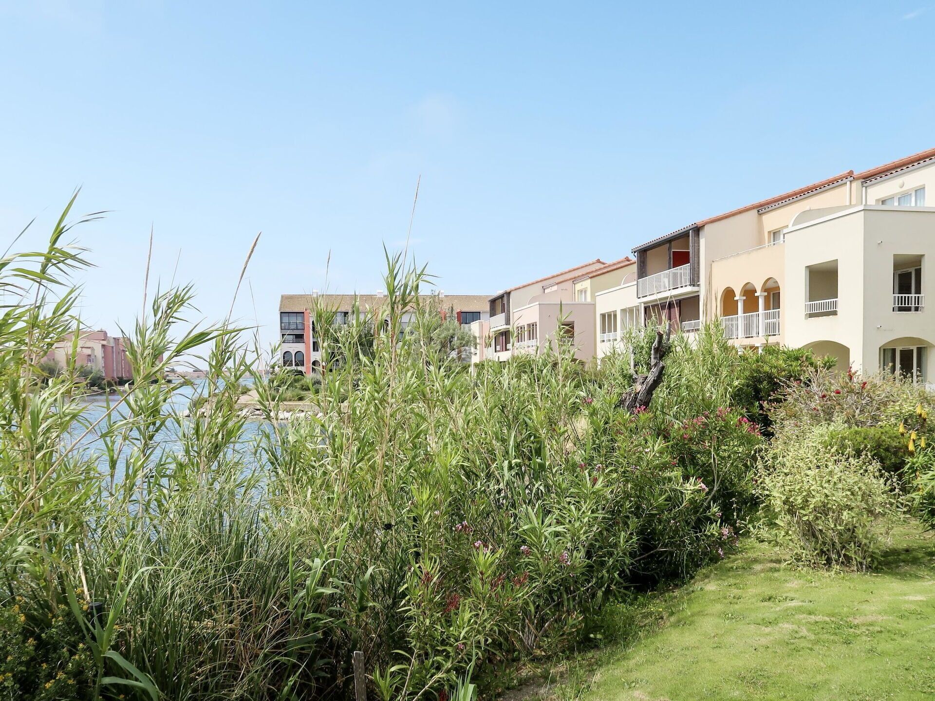 Een hotel met meerlaags gebouwen, een zwembad en weelderige begroeiing.