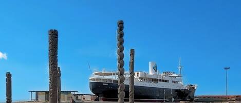 A large ship docked at a port with a clear sky.