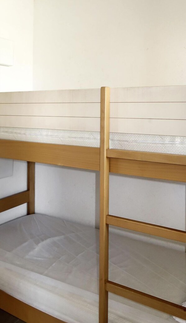 A bunk bed with a wooden frame and a mattress.