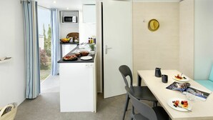 A compact, modern room with a dining area, a kitchenette, and a view of the outdoors. - Nice apartment in villa for 6 people with WIFI, A/C, pool, TV, terrace and pets allowed (Argelers)