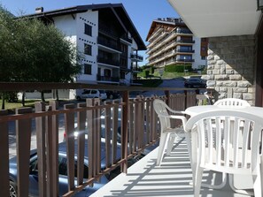 Enjoy the view from this balcony overlooking a residential neighborhood with a mix of modern and traditional architecture.