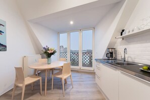 Une cuisine moderne avec un coin repas, de grandes fenêtres et une vue sur la ville.