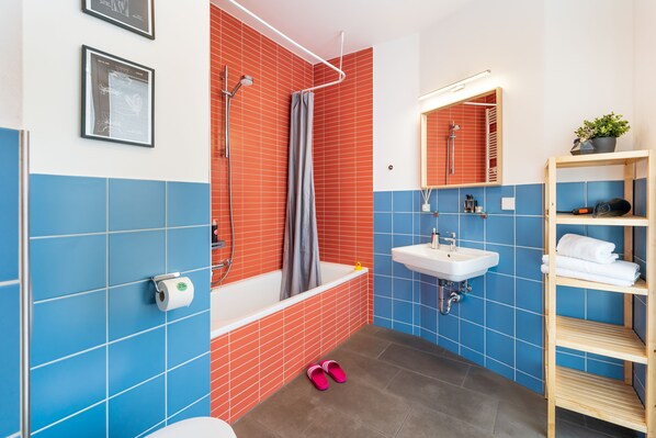 Un baño moderno con bañera, ducha y lavabo.