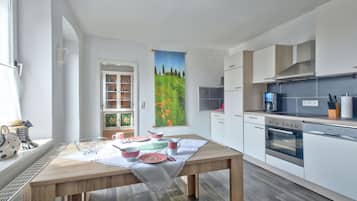 Mikrobølgeovn, ovn, oppvaskmaskin og spisebord