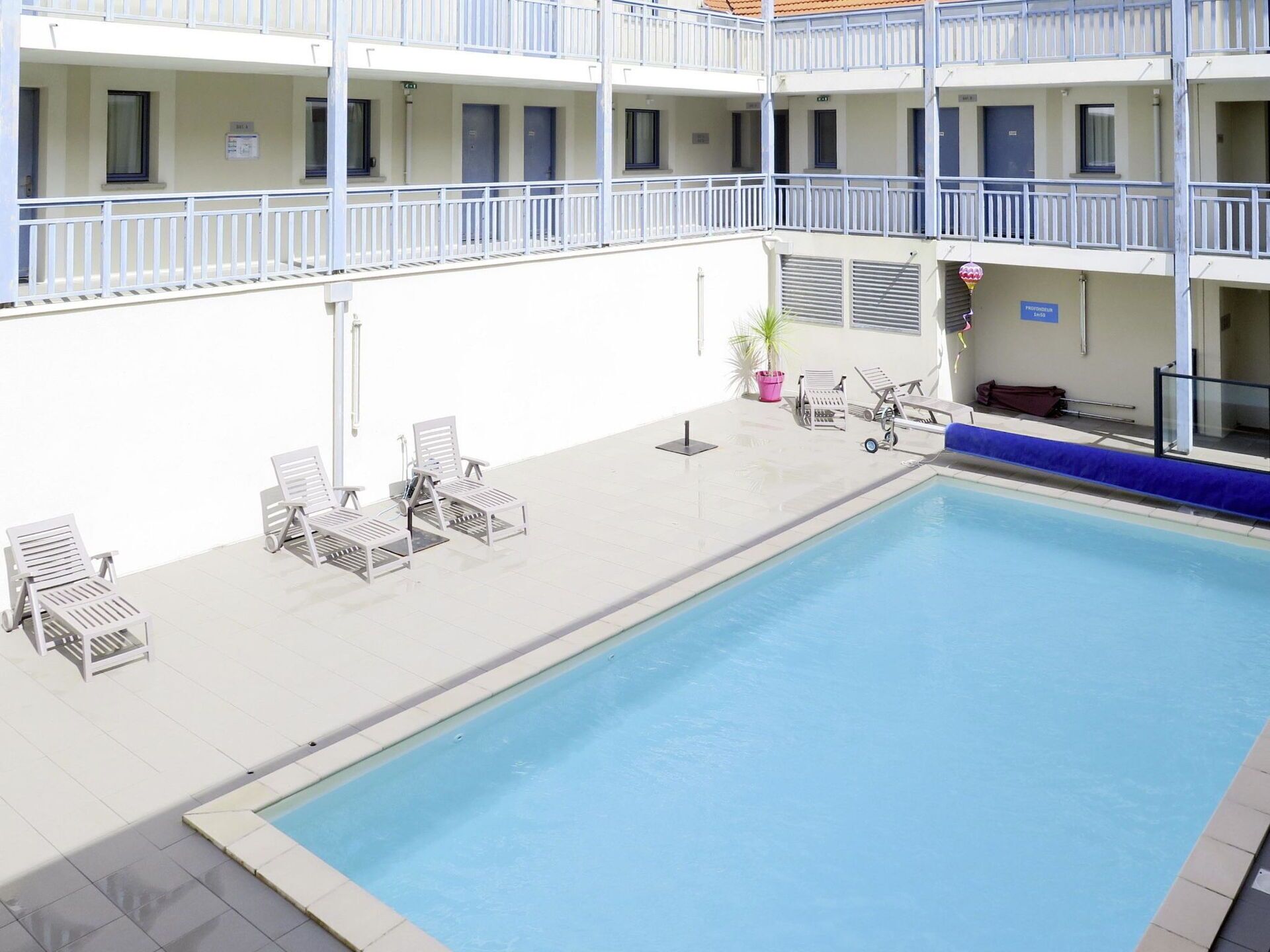 Ein Poolbereich mit Liegestühlen und einem kleinen Pool.