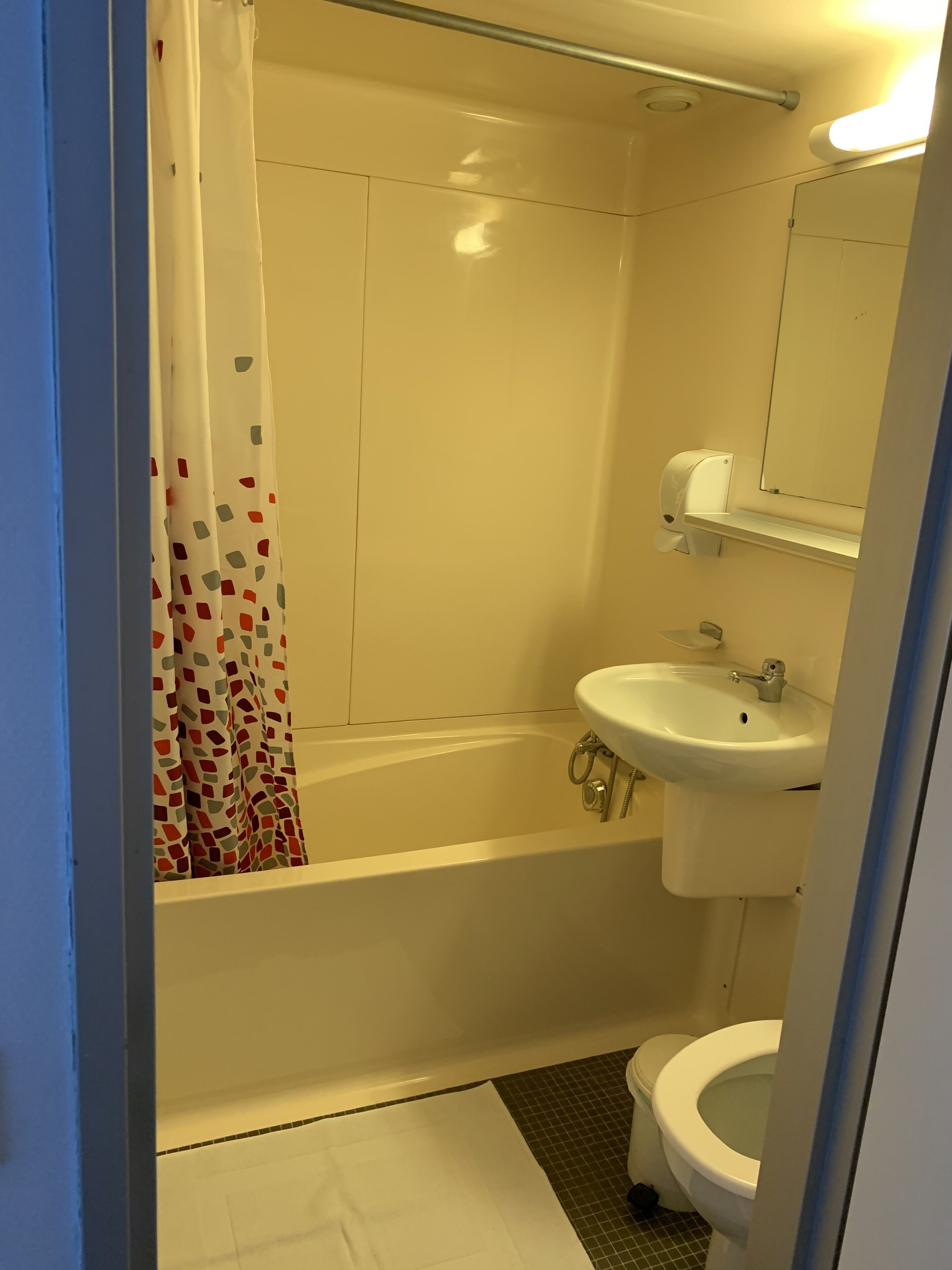 A bathroom with a bathtub, sink, toilet, and a shower curtain.