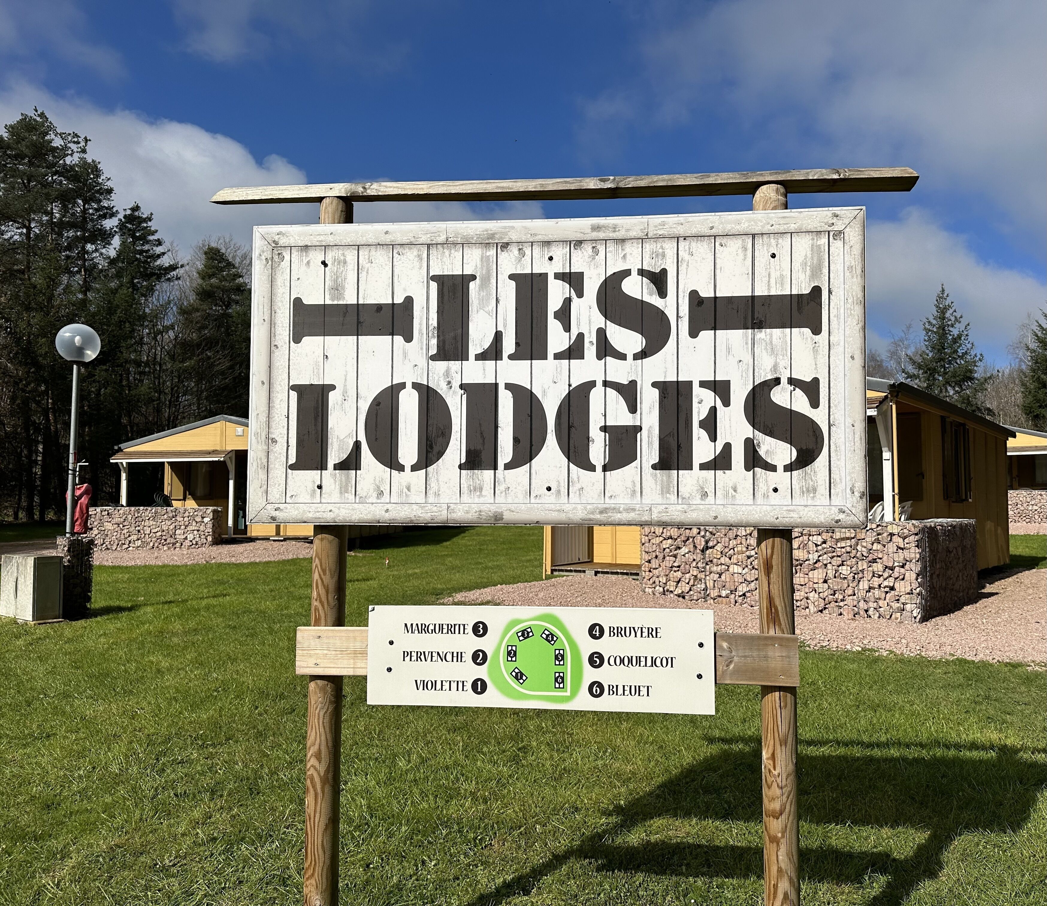 A sign for 'LES LODGES' with a list of lodges and their numbers.
