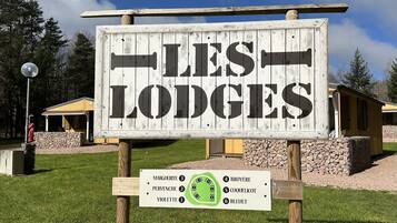 A sign for 'LES LODGES' with a list of lodges and their numbers.