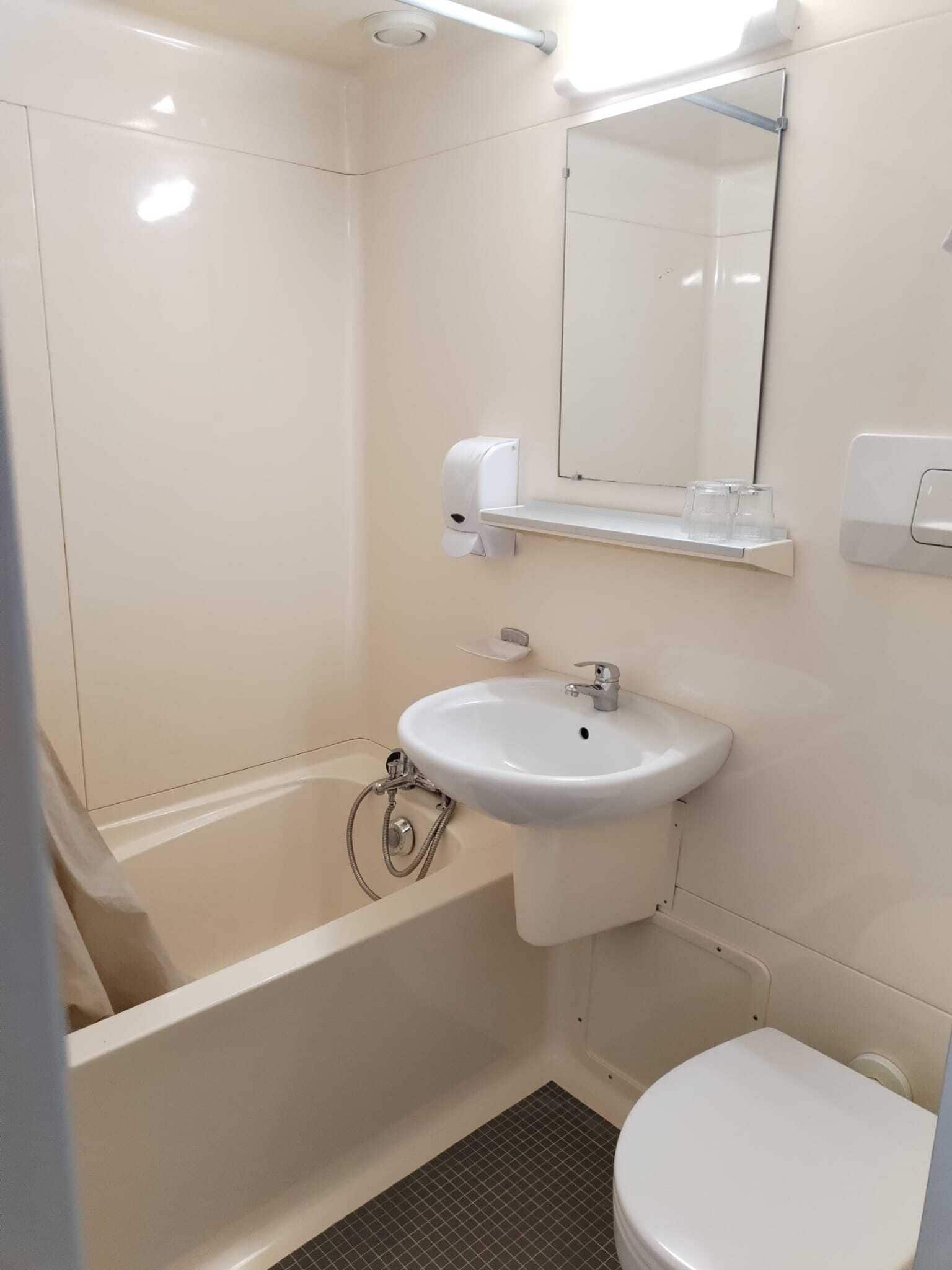 Een badkamer met een bad, een wastafel en een toilet.