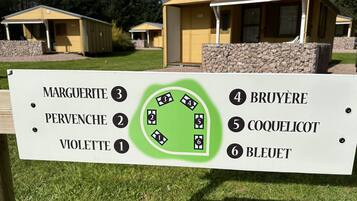 A directional sign with numbered sections for different areas: Marguerite, Pervenche, Violette, Bruyère, Coquelicot, and Bleuet.