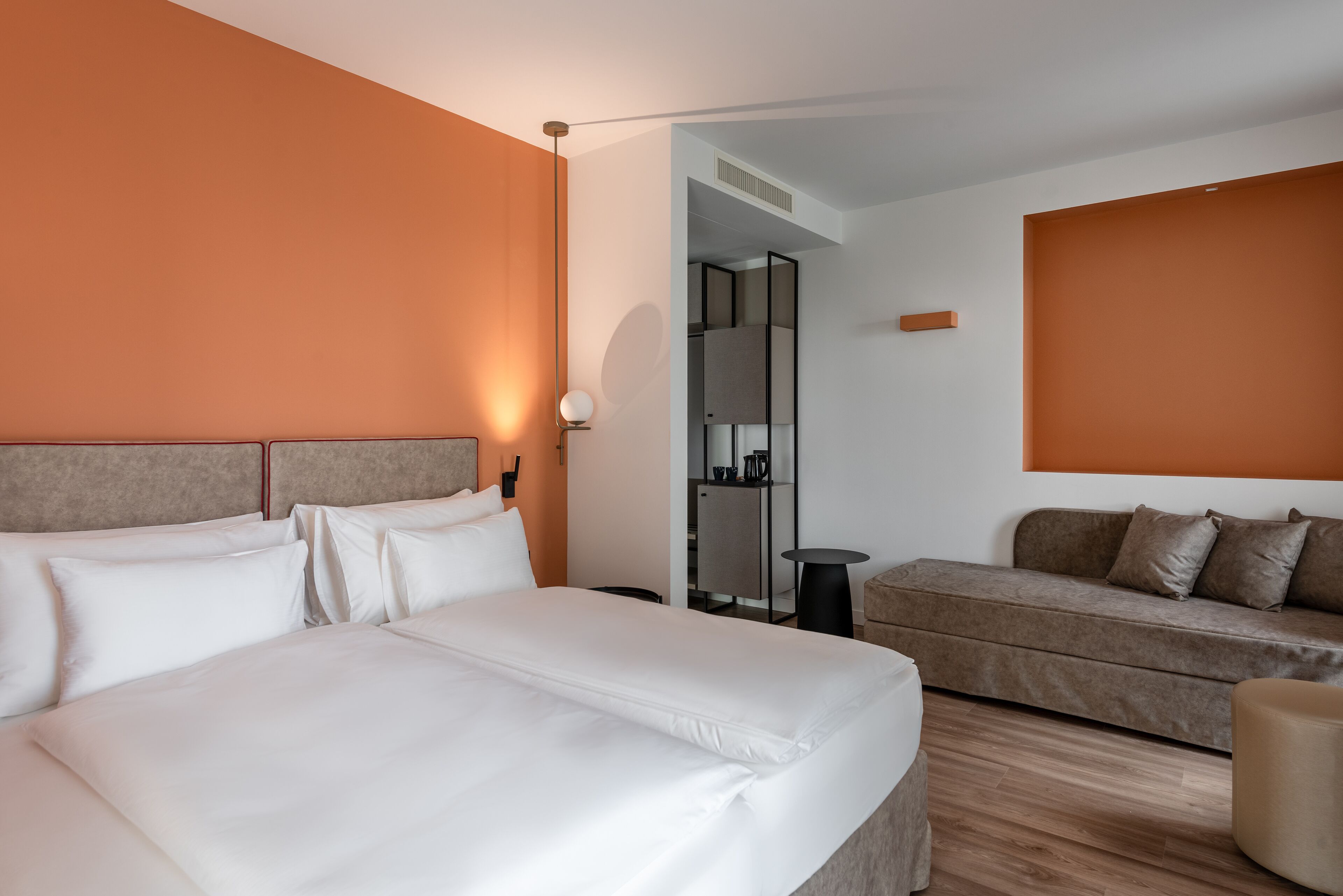 Una habitación de hotel con una cama grande, un sofá y una mesita.