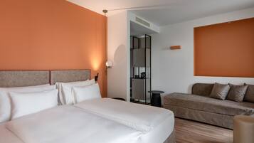 Una habitación de hotel con una cama grande, un sofá y una mesita.