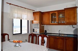 Une cuisine avec des meubles de rangement en bois, un four à micro-ondes et un évier.