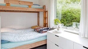 A bunk bed with a wooden headboard, a white dresser, and a window with curtains. - 6 Person Holiday Home in Roslev-by Traum (Roslev)