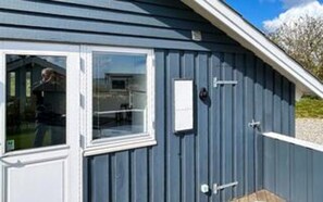 A building with a window, a door, and a small rectangular object on the wall. - 4 Star Holiday Home in Borkop (Borkop)