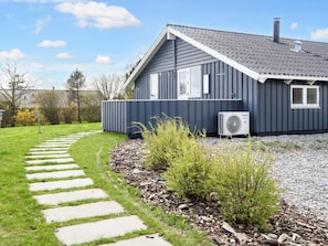 A modern house with a grey exterior, a sloped roof, and a visible air conditioning unit. - 4 Star Holiday Home in Borkop (Borkop)