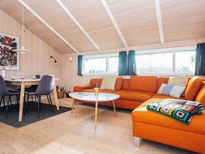 A cozy living room with a wooden ceiling, a round coffee table, an orange sofa, and a colorful blanket. - 4 Star Holiday Home in Borkop (Borkop)
