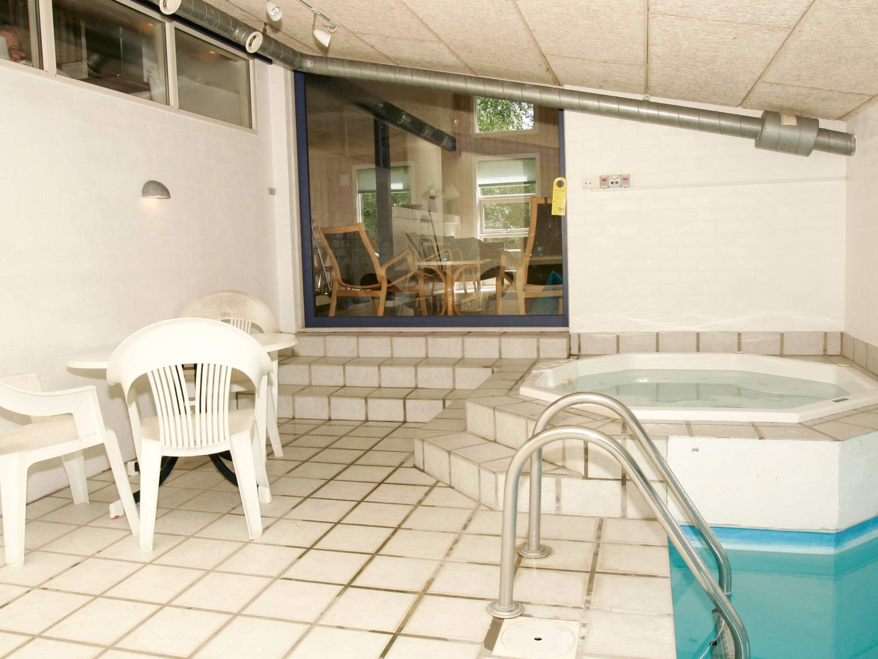 Ein Wellnessbereich mit Whirlpool, einem Tisch und Stühlen.