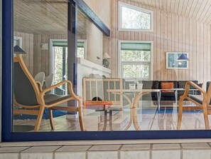 A room with wooden walls, a glass partition, and a seating area with chairs and a table. - 14 Person Holiday Home in Nexo (Nexø)
