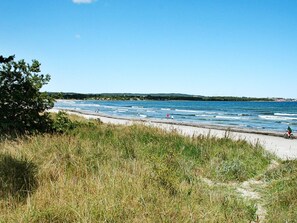 A beach with a sandy path, grassy areas, and a clear blue sky. - Cozy Holiday Home in NexÃ¸ near Beach of Balka (Nexø)