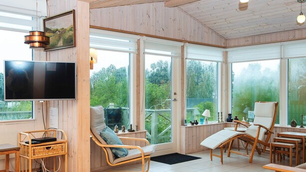 A spacious room with large windows, wooden flooring, and a flat-screen TV. - 7 Person Holiday Home in Knebel-by Traum (Knebel)