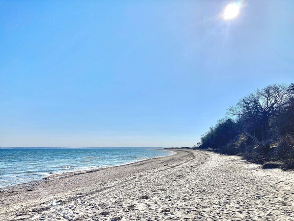 A beach with a clear sky and calm sea.