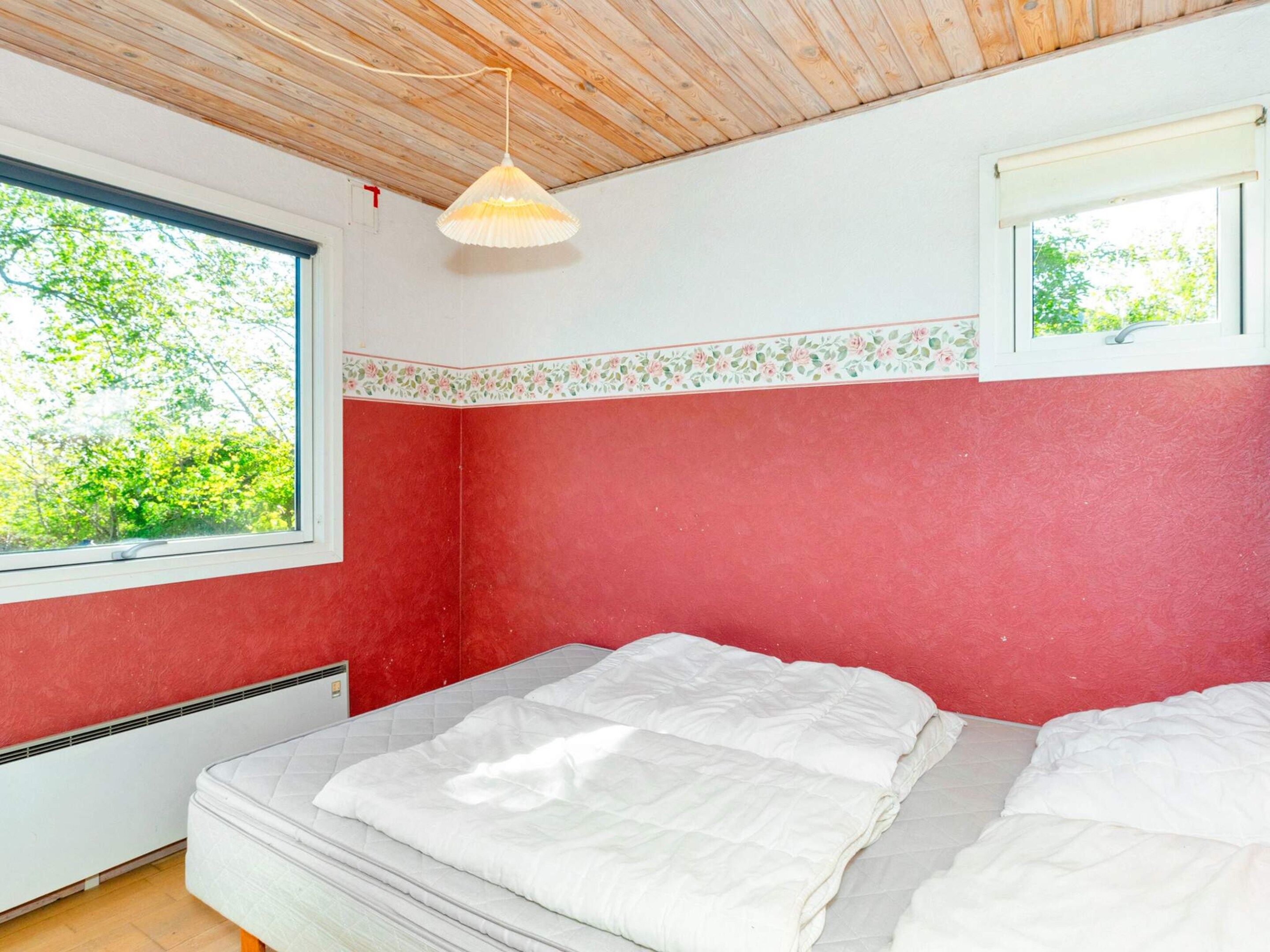 Una habitación con cama, ventana y ventilador de techo.