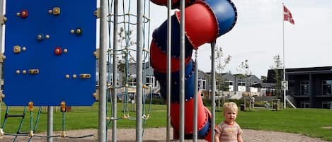 Une aire de jeux avec des structures d’escalade et un toboggan.