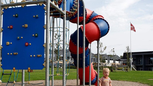 Une aire de jeux avec des structures d’escalade et un toboggan.