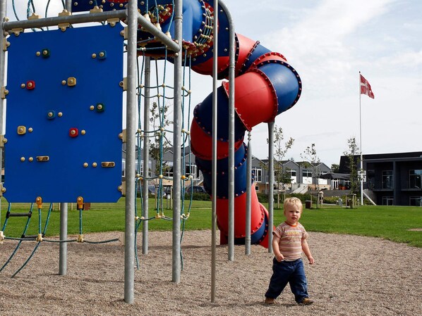 Une aire de jeux avec des structures d’escalade et un toboggan.