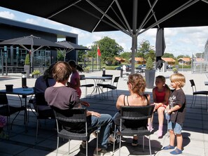 An outdoor seating area with tables and chairs under a large umbrella.