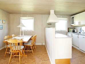 Cozy kitchen and dining area with a central island and wooden table for meals.