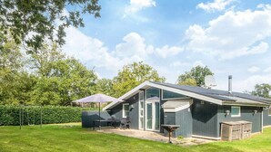 A house with a patio, a swing set, and a satellite dish.
