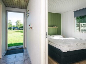 Un dormitorio con una cama, una pared verde y una ventana.