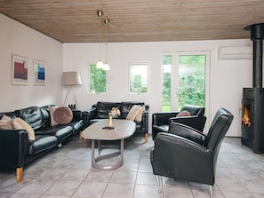 A living room with a black leather sofa, a round coffee table, and a fireplace.
