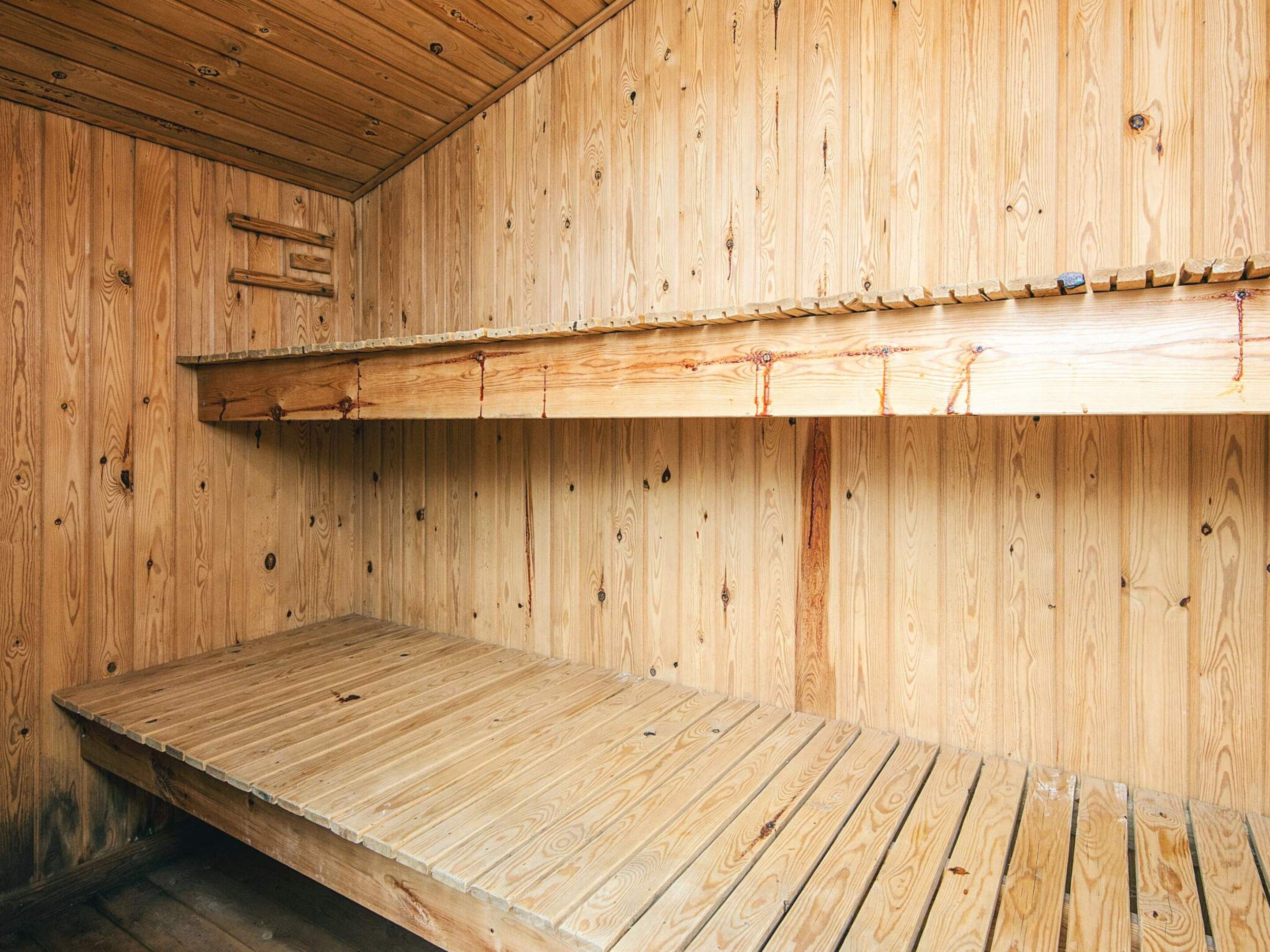 Un intérieur en bois avec un lit superposé et une surface de couchage plane.