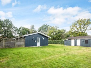 A fenced property with a single blue building, a smaller attached structure, and a well-maintained lawn. - 8 Person Holiday Home in Orsted (Ørsted)