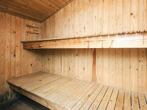 A wooden interior with a bunk bed and a flat sleeping area.