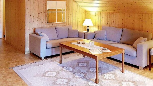 A wooden interior with a sofa set, a table, and a lamp. - 5 Person Holiday Home in Lammhult, Sverige (Lammhult)