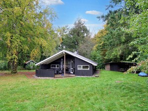 A small cabin with a sloped roof, a deck, and a covered outdoor area. - 8 Person Holiday Home in Melby (Melby)