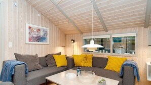 A cozy living room with a grey sofa, yellow cushions, a coffee table, and a painting on the wall. - 8 Person Holiday Home in Melby (Melby)