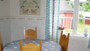 A dining table with a floral tablecloth, wooden chairs, and a vase. - 4 Person Holiday Home in Gullspang (Gullspång)