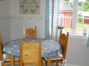 A dining table with a floral tablecloth, wooden chairs, and a vase. - 4 Person Holiday Home in Gullspang (Gullspång)