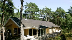 Une cabane dotée d’un porche, d’un espace extérieur aménagé pour s’asseoir et d’une terrasse couverte.