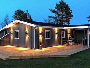 A modern house with a wooden deck, outdoor lighting, and a covered patio area. - 4 Star Holiday Home in Haderslev (Haderslev)