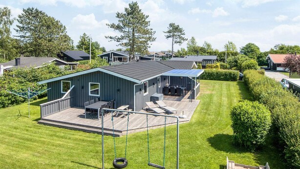 A residential area with a house featuring a deck and outdoor seating area. - 4 Star Holiday Home in Haderslev (Haderslev)